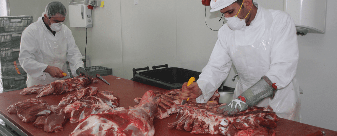 Mitarbeiter portionieren Fleisch